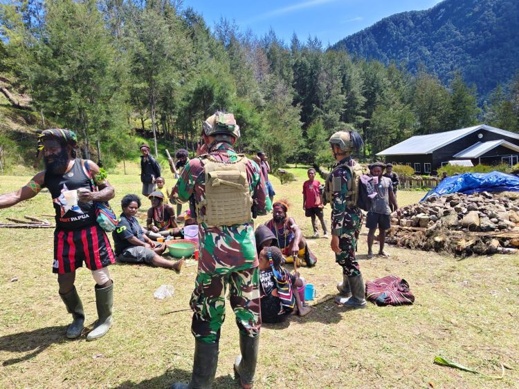 Satgas Yonif 700/WYC Bantu Warga Siapkan Acara Bakar Batu di Kampung Wuloni